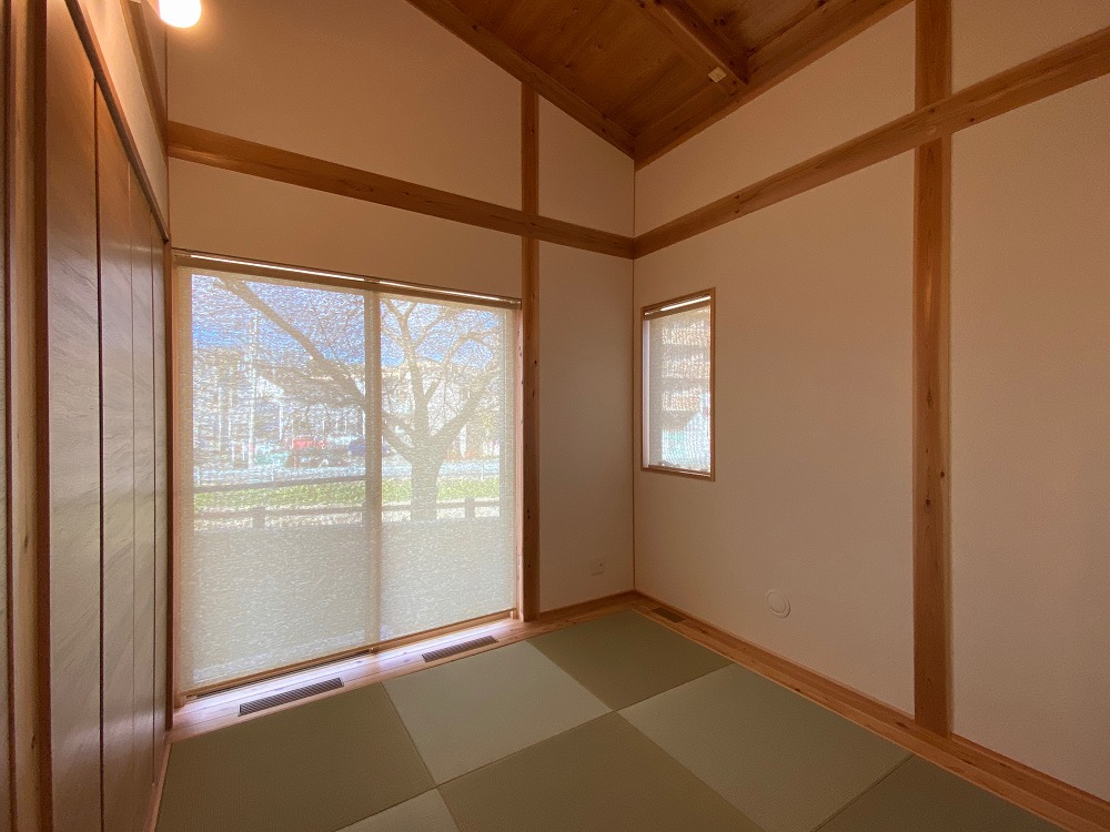 西側居室。畳、板間、木の勾配天井。寝転ぶとても落ち着く空間になっている