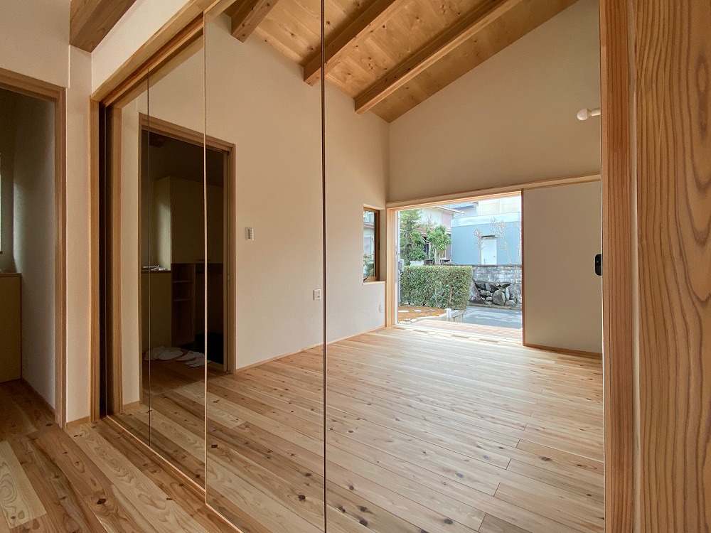 家族が一緒になって運動をする居間スペース。続きの間を仕切る製作建具に鏡を仕込んだ